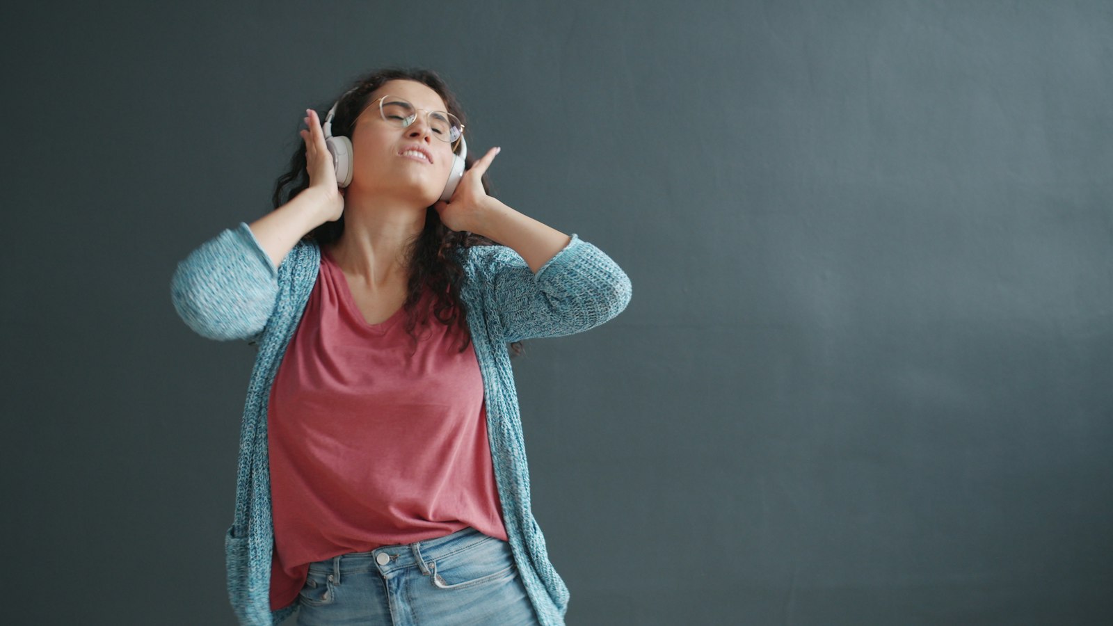 Woman dancing to music in headphones, wondering if weed makes you a better dancer